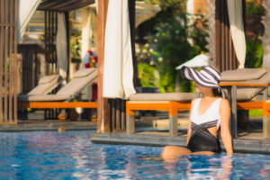 Beautiful portrait young asian woman happy smile relax around swimming pool in resort hotel for leisure